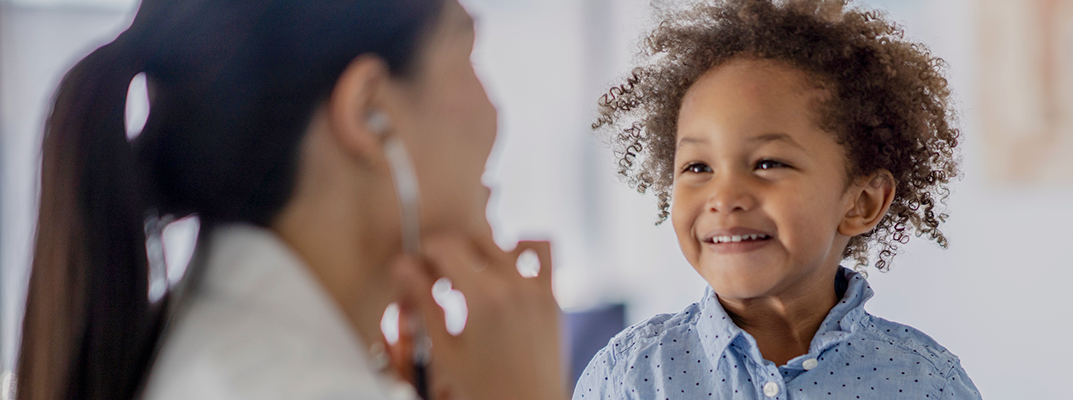 Child smiling during a checkup with the doctor.
