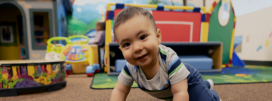 Baby boy crawling on the floor at the Monument First 5 Center